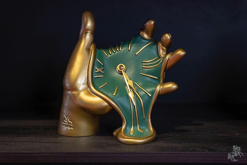 Schmilzende Uhr in einer Hand