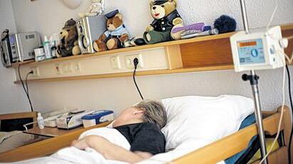 Ein Patient liegt in einem Krankenhausbett