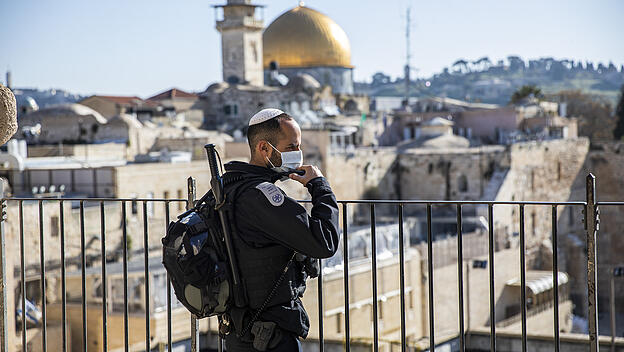Israelischer Polizist mit Mundschutz steht in der Altstadt Wache
