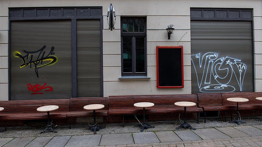 Leere Tische und Bänke stehen vor einer Kneipe in der Altstadt von Halle/Saale