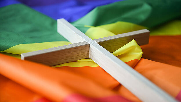 Kreuz auf Regenbogenfahne
