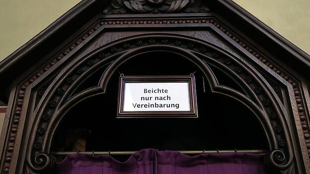 Hinweis "Beichte nur nach Vereinbarung" am Beichtstuhl steht in einer Kirche in Bonn