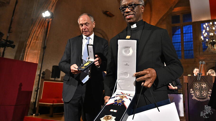 Apostolischer Nuntius Jude Thaddeus Okolo nimmt den Orden für Johannes Paul II. entgegen.