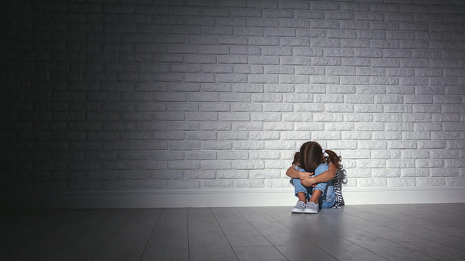 Kind vor einer Wand