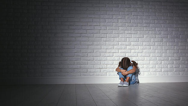 Kind vor einer Wand