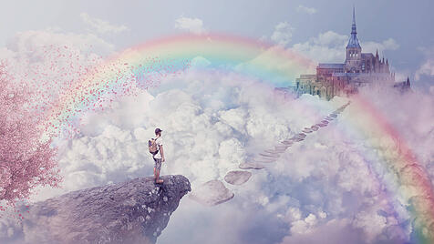 Fantasy world imaginary view. Young boy looking at the path to a castle above clouds. Life journey below a rainbow in pa