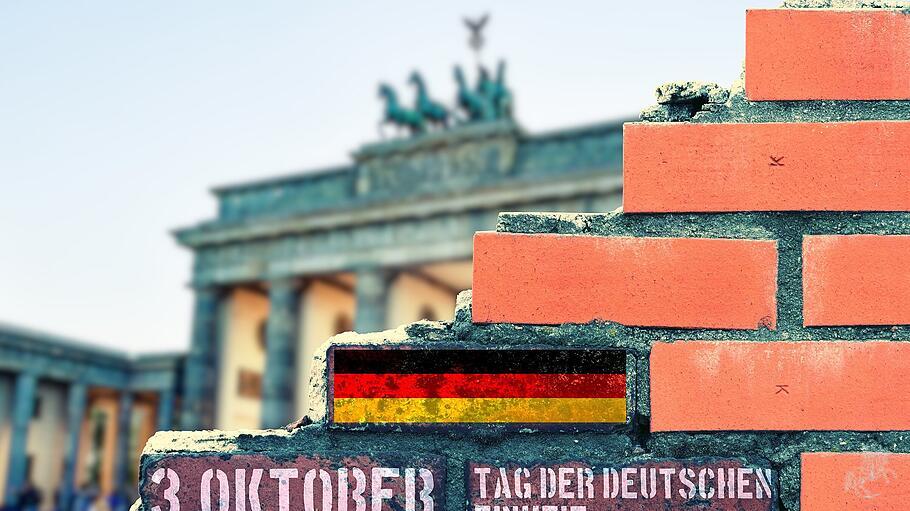 Eine Mauer in Berlin und Hinweis auf den 3. Oktober