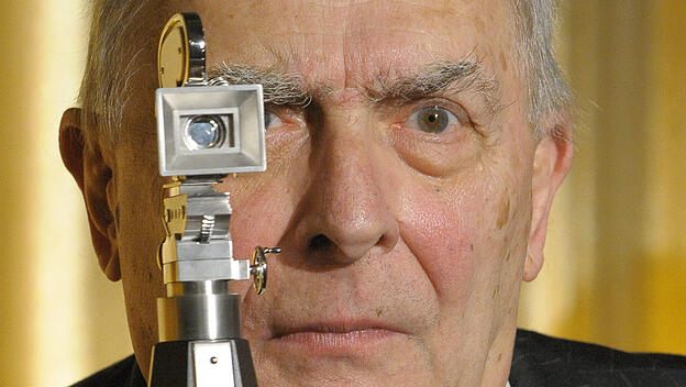 Claude Chabrol posiert mit der ihm verliehenen "Berlinale-Kamera".