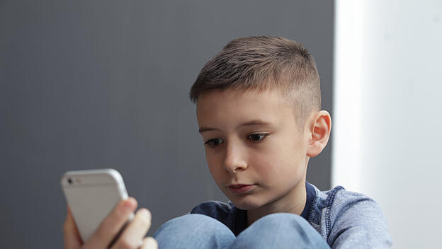 Upset boy with smartphone