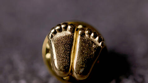 Ein Füßchenanstecker, nachempfunden den Füßen eines wenige Wochen alten Fötus