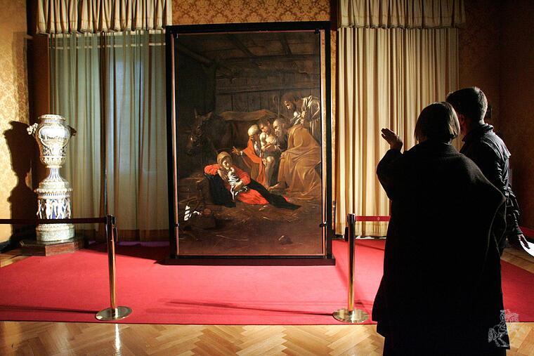 Menschen vor dem restaurierten Bild "Die Anbetung der Hirten" von Caravaggio