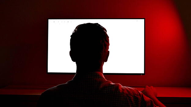 Mann schaut auf Computerbildschirm