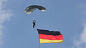 Freifaller des Fallschirmjägerregiment 26 mit Flaggen der Bundesrepublik Deutschland