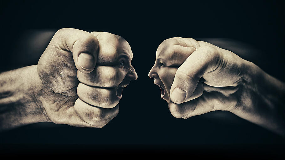 Geschlechterkampf: zwei Fäuste je mit einem weiblichen und einem männlichen Gesicht in Konfrontation