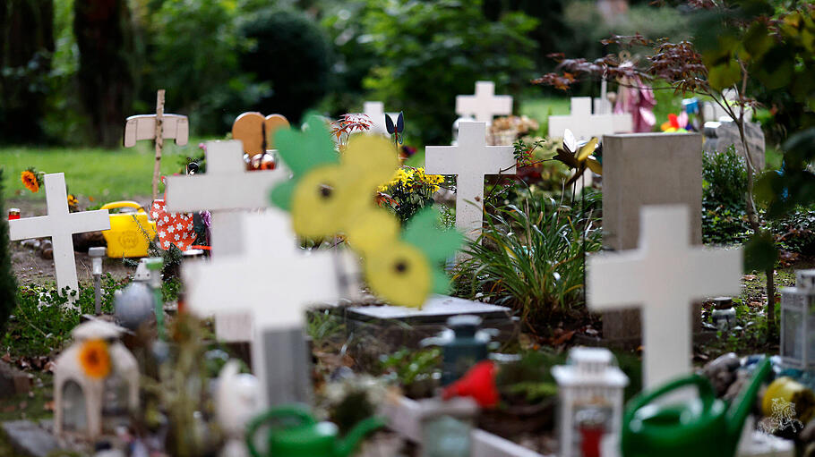Windspiele, Blumen und Spielzeuge schmücken Kindergräber auf dem Kölner Melaten-Friedhof.