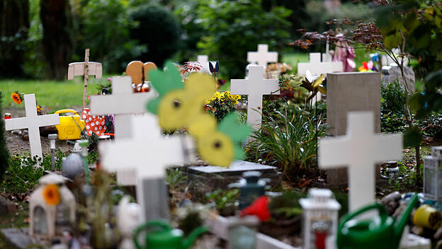 Windspiele, Blumen und Spielzeuge schmücken Kindergräber auf dem Kölner Melaten-Friedhof.