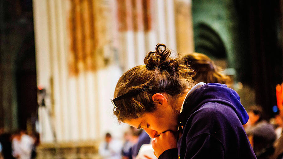 Eine junge Frau betet in Notre Dame de Chartres
