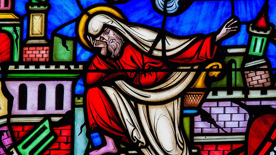 In der Brüsseler Kathedrale ist Jeremia auf einem farbigen Glasfenster abgebildet, er wendet sich ab: Hinter ihm geht Jerusalem in Trümmer.