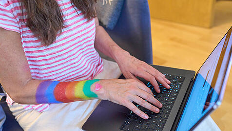 Junge Frau mit Regenbogenfarben am Arm