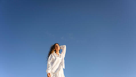 Frau vor blauem Himmel