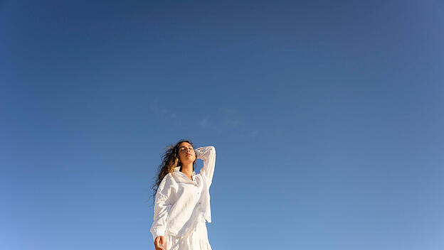 Frau vor blauem Himmel