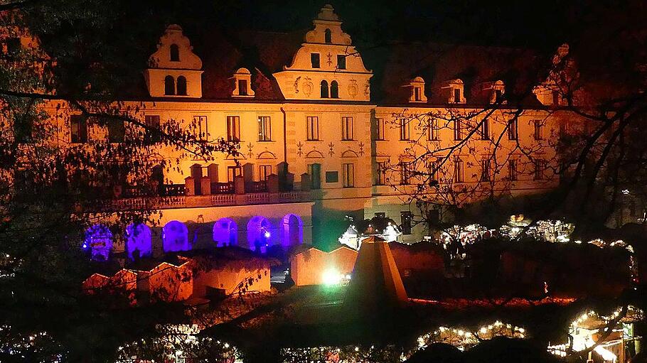 Kulisse des barocken Regensburger Schlosses vor den Buden des Christkindlmarktes