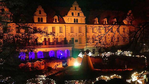 Kulisse des barocken Regensburger Schlosses vor den Buden des Christkindlmarktes