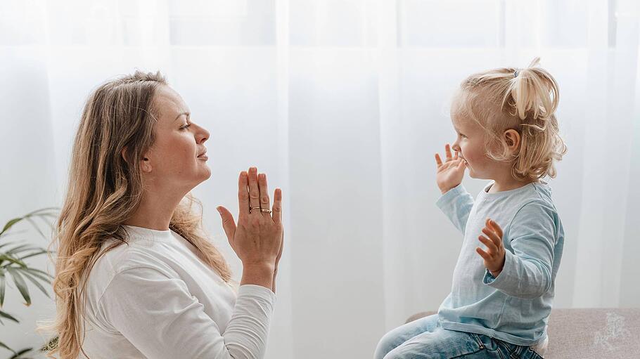 Mutter betet mit ihrem Kind zu Hause