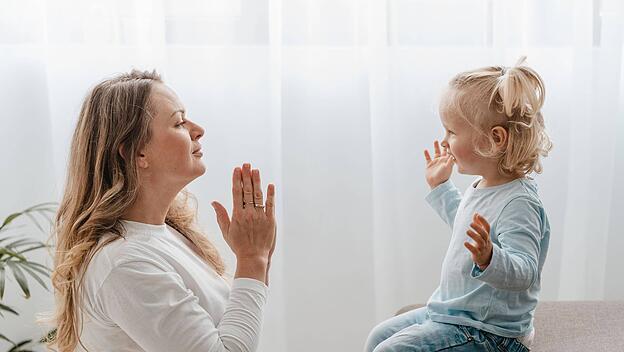 Mutter betet mit ihrem Kind zu Hause