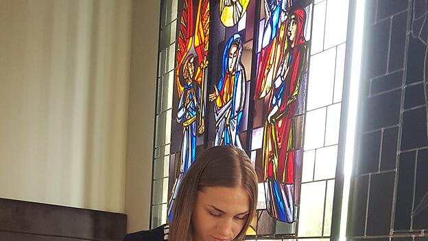 Maria liest in der Kapelle der Home Base in Passau in der Bibel