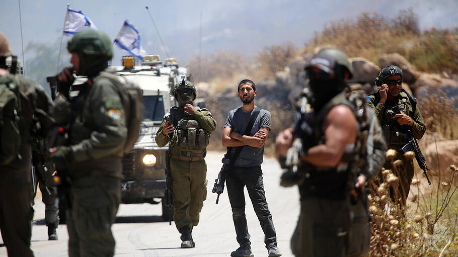 Israelische Soldaten und Siedler blockieren Anfang Juni östlich von Idhna bei Hebron im Westjordanland Zufahrtswege