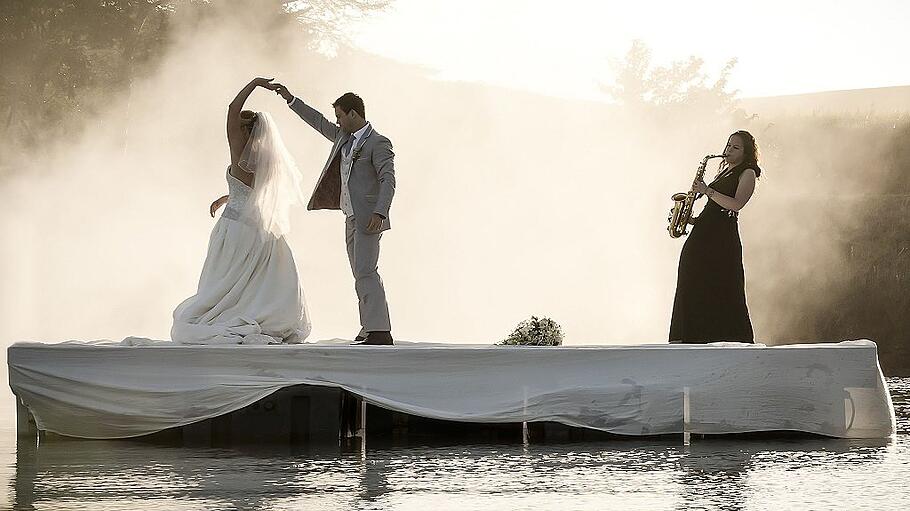Bride and Groom dancing on a lake to music.