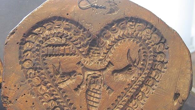 Holzmodell zeigt  Jesusknaben als Wickelkind mit Ochs und Esel.