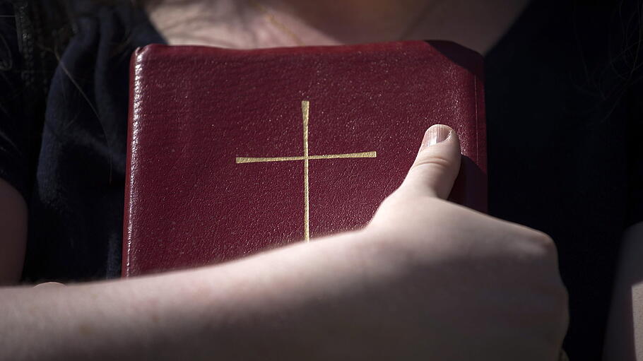 Eine Frau hält eine Bibel im Arm