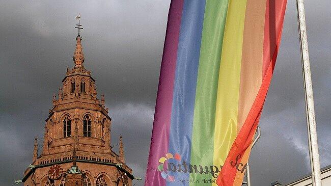Symbolbild zum Thema Homosexualität und Kirche: Regenbogenflagge weht vor dem Dom in Mainz, Rheinland Pfalz, Deutschland