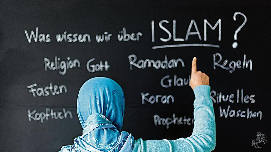 Eine muslimische Sch&uuml;lerin vor einer Tafel mit Begriffen aus dem Islam im Islamunterricht