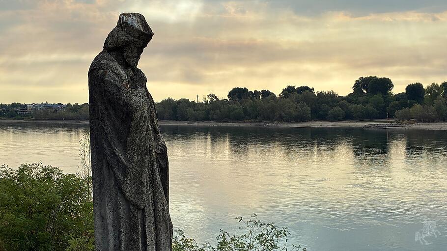 Der heilige Nepomuk am Rheinufer bei K&ouml;ln als Mahnmal: dramatische Klimafolgen sind auch Aufforderung zu Selbstkritik und Umkehr.