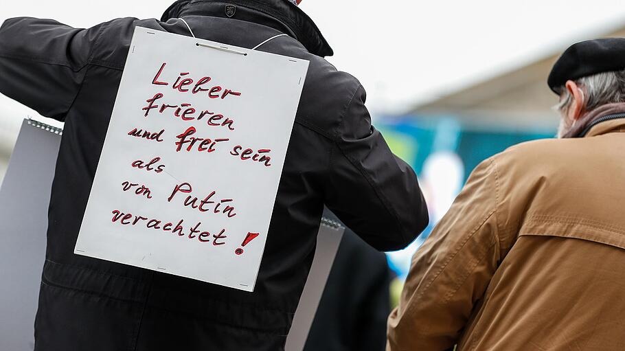 Mann trägt ein Schild auf dem Rücken auf dem steht «Lieber frieren und frei sein als von Putin verachtet!»