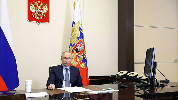 Putin schaut skeptisch auf einen Computer