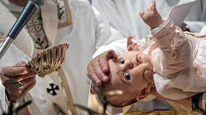 Pope Francis baptises a baby during a ceremony in the Sistine Chapel at the Vatican
