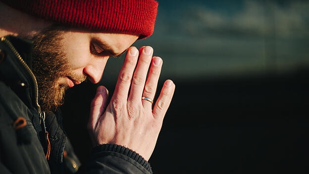 Mann betet zu Gott