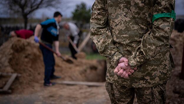Ukrainischer Soldat hält inne während der Beerdigung seines Vaters