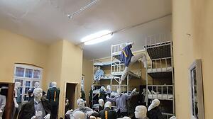 In einer figürlichen Installation wird die menschenunwürdige Überbelegung in der Haftanstalt für die Besucher erfahrbar.