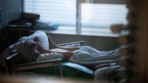 Patient liegt in einem Zimmer auf einer Corona-Intensivstation