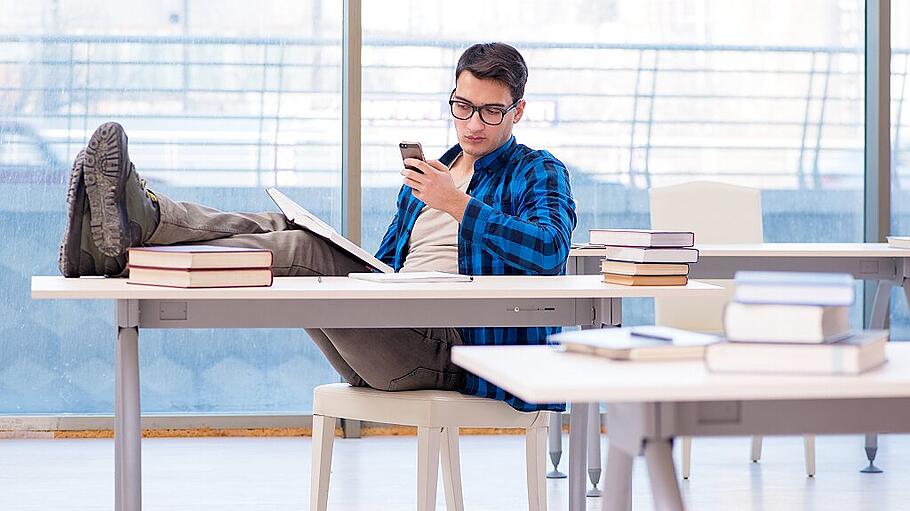 Student studying in the empty library with book preparing for ex