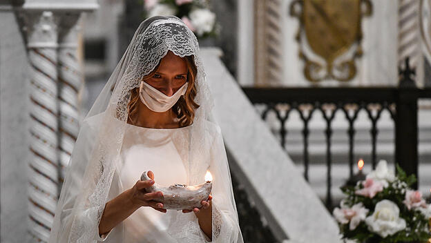 Eine Frau hält bei einer Jungfrauenweihe am 31. Oktober 2020 in der Lateranbasilika in Rome eine Öllampe in den Händen.