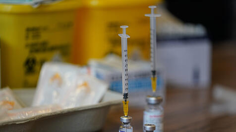 Spritze gesteckt in Impfampulle
