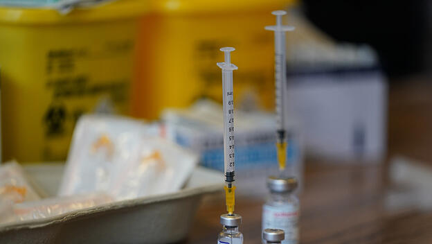 Spritze gesteckt in Impfampulle