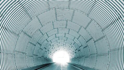 Innenansicht eines Tunnels mit hellem Tunnelausgang