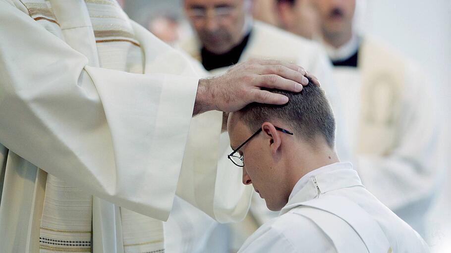 Ein junger Geistlicher wird zum Priester geweiht.
